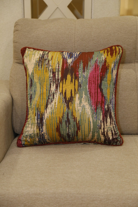 Multicoloured ikat stripe printed silk cushion cover styled on a linen armchair