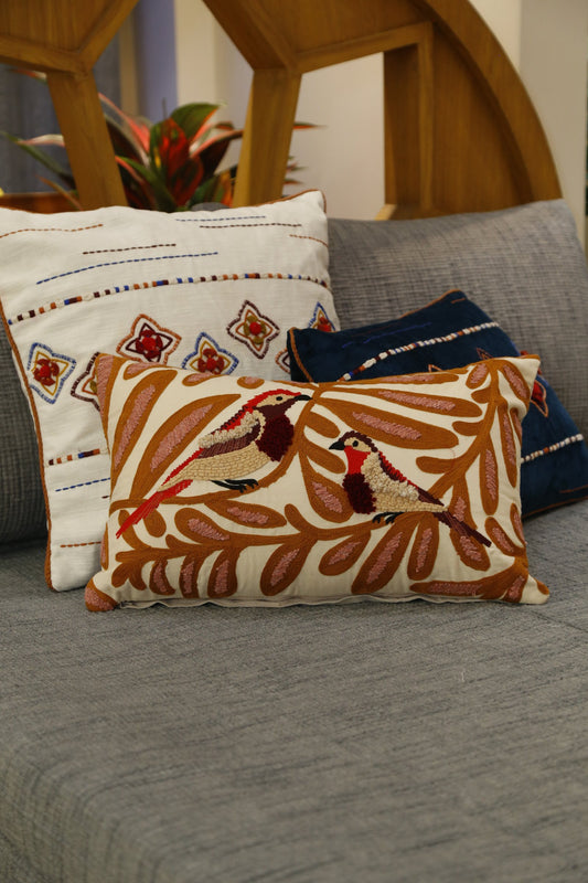 Cotton slub cushion cover embroidered with birds among rust and ochre vines, front view