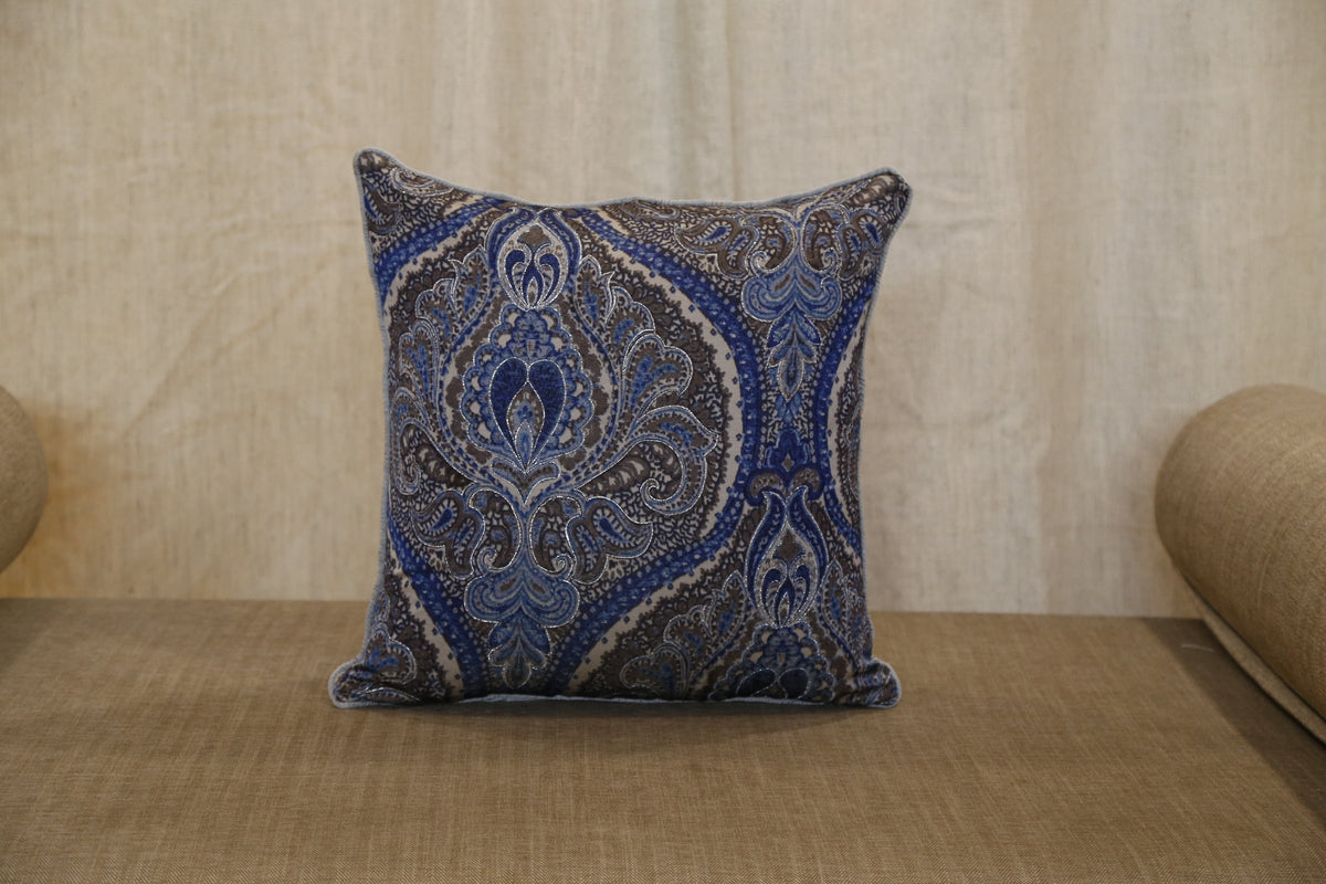 Silver blue paisley printed silk cushion cover styled on a bench, front view, 18x18 inches