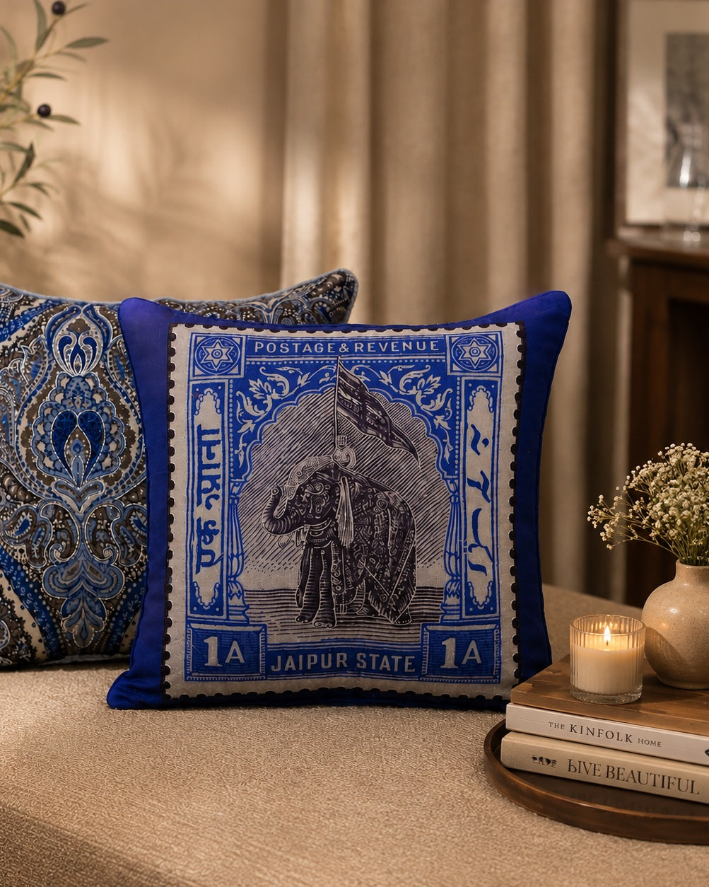 Jaipur elephant stamp cushion styled with a paisley cushion beside a candle