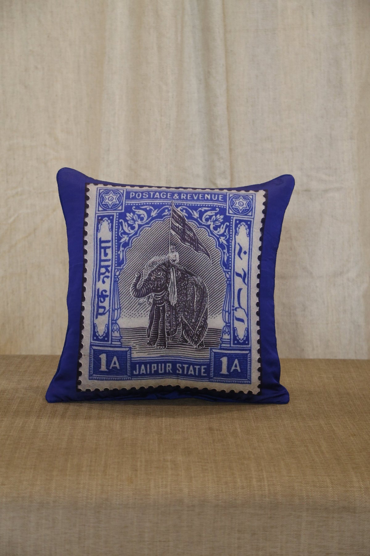 Royal blue Jaipur elephant stamp cushion cover styled on a woven bench