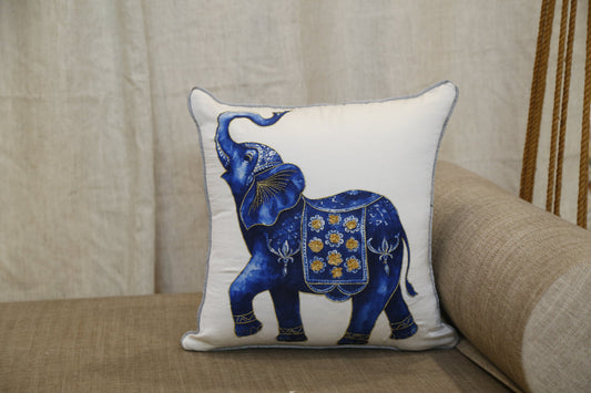Ivory silk cushion cover printed with a cobalt and gold ceremonial elephant, front view
