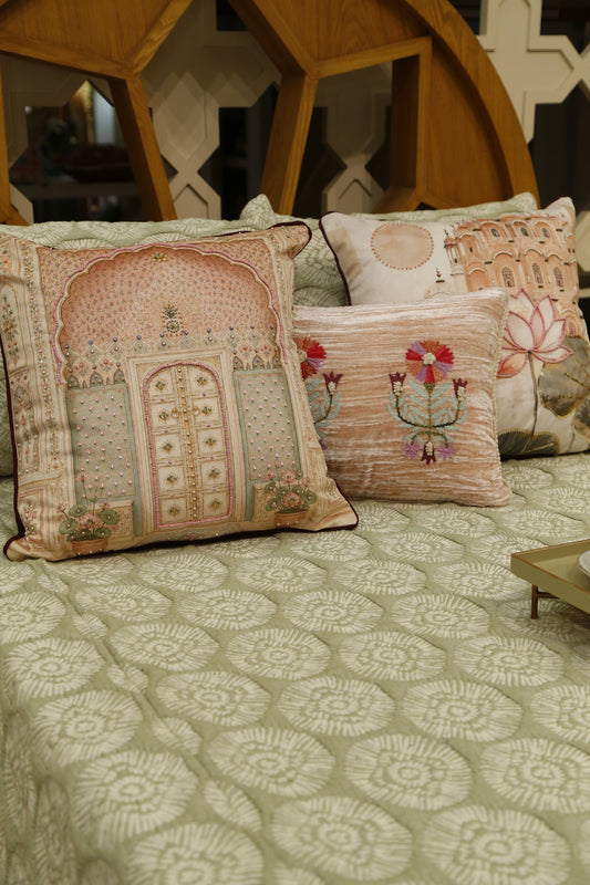 Blush pink jharokha beaded velvet cushion cover styled on a bed