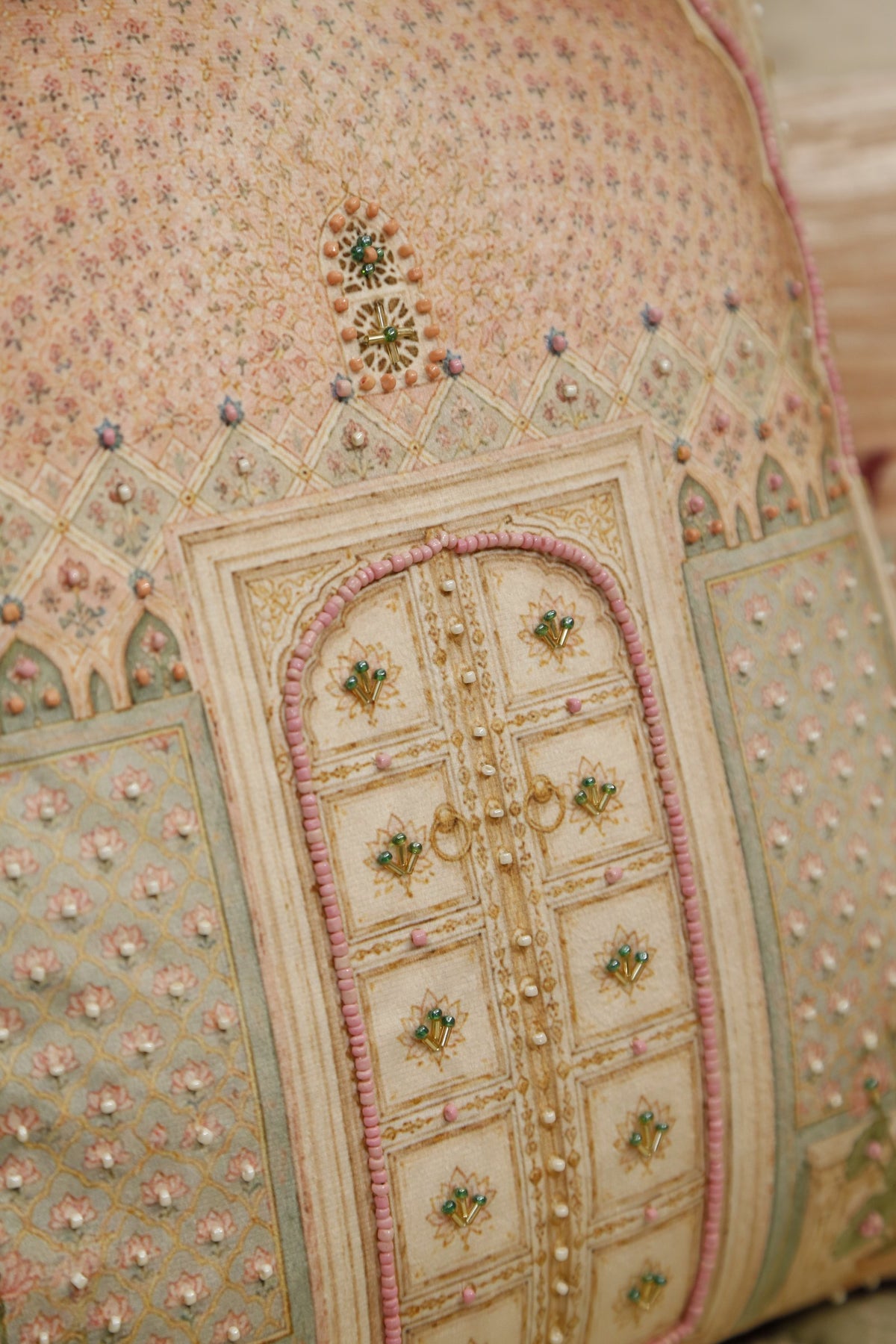 Close detail of the jharokha window motif and bead embroidery on blush pink velvet