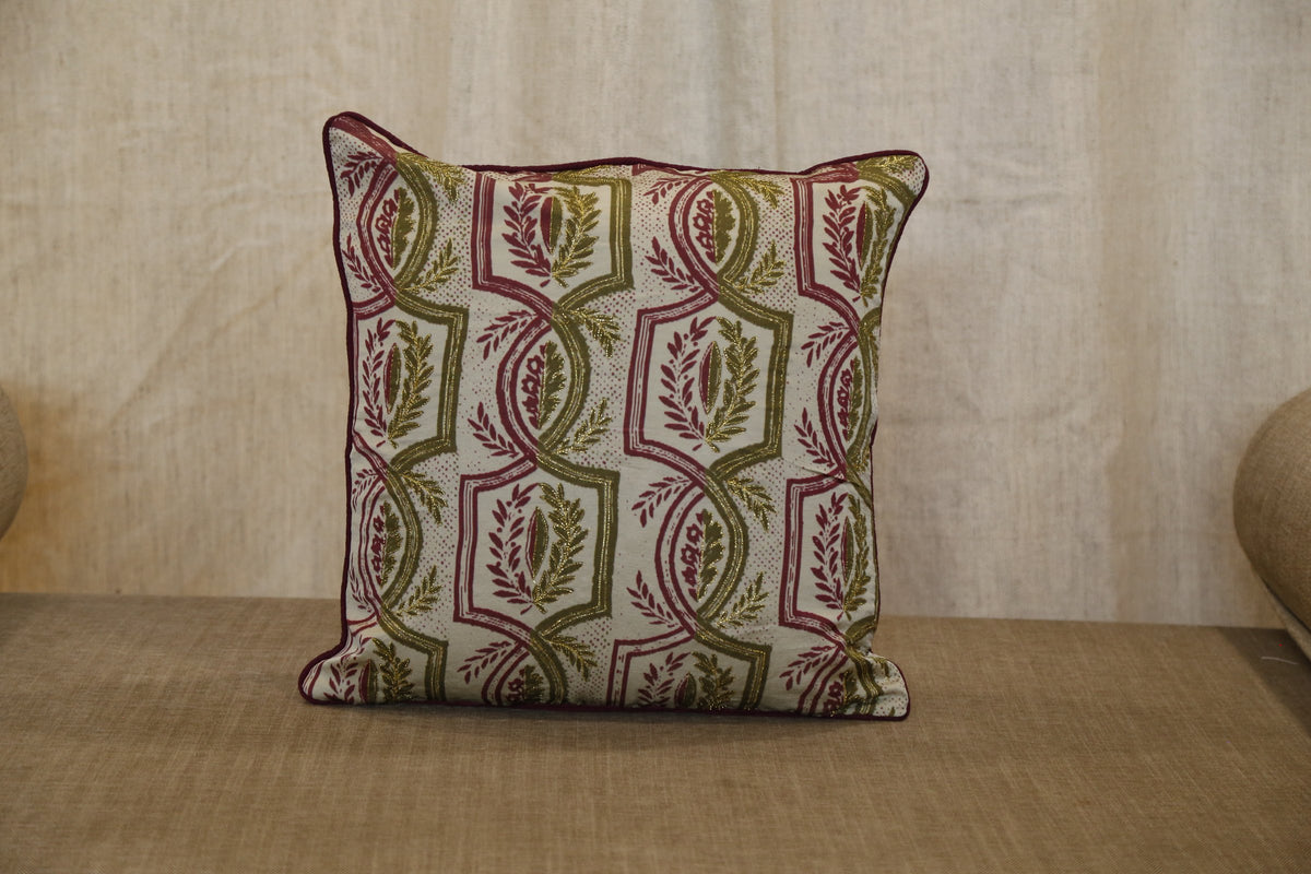 Olive green trellis silk cushion cover, angled view showing red piping