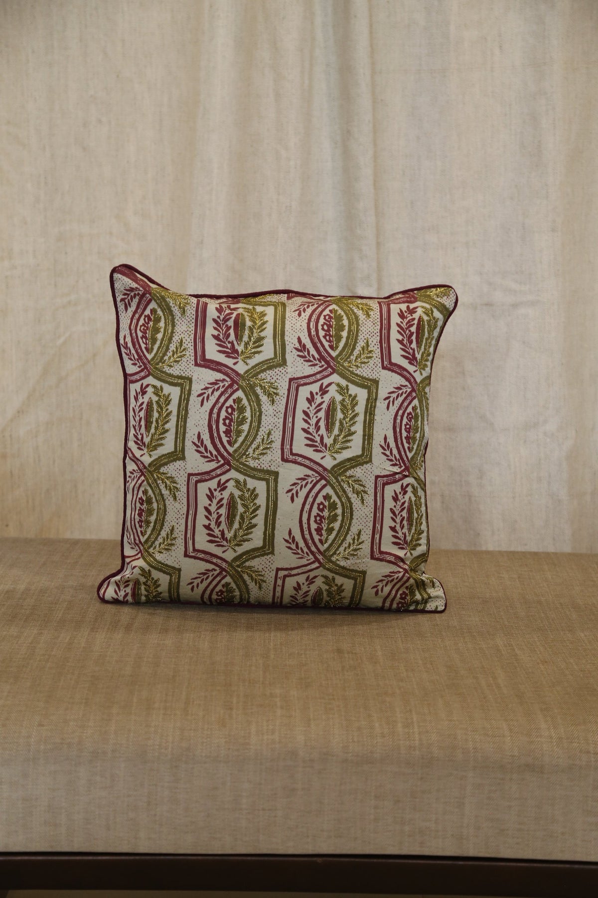 Olive green trellis silk cushion cover styled on a linen bench