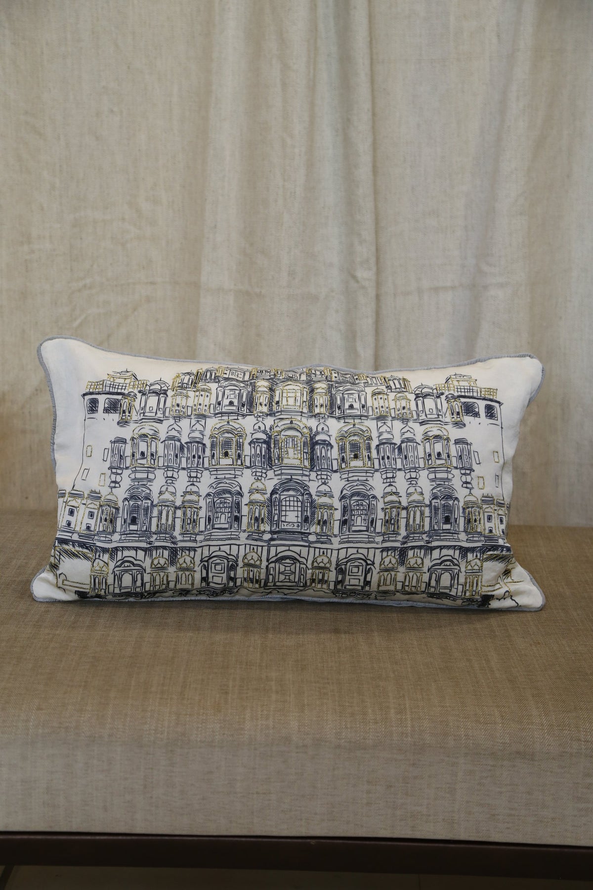 Ivory haveli zari silk lumbar cushion cover on a linen bench