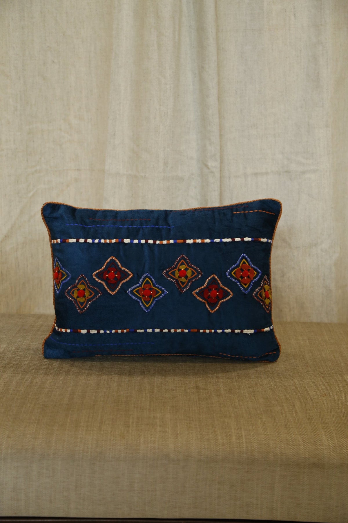 Indigo blue lumbar cushion cover with traditional diamond embroidery, front view