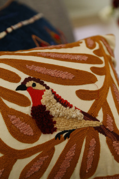 Close detail of the hand-embroidered bird and vine motif